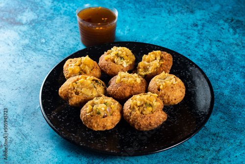 Pakistani spicy gol gappay, indian pani puri and bangali fuchka full of chaat masala with sour water in a dish isolated on marble background top view of indian street food