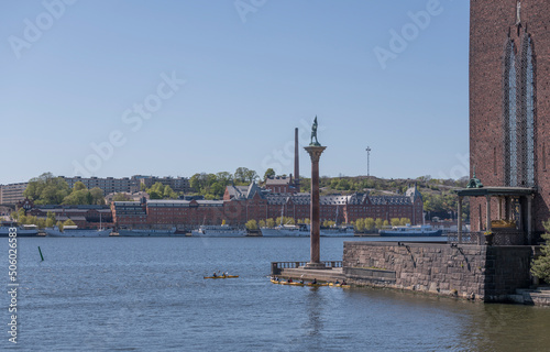 The parterre of the Town City Hall with canoers and the skyline of the district Södermalm a sunny day in Stockholm