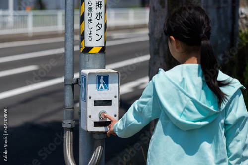 交差点の障害者用ボタンを押す子供の姿