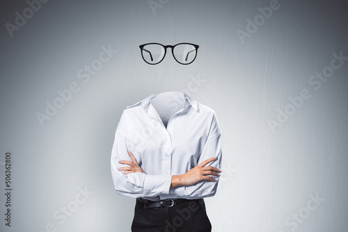 Headless invisible businesswoman with folded arms and abstract glasses standing on gray wall background. Business and secret concept.