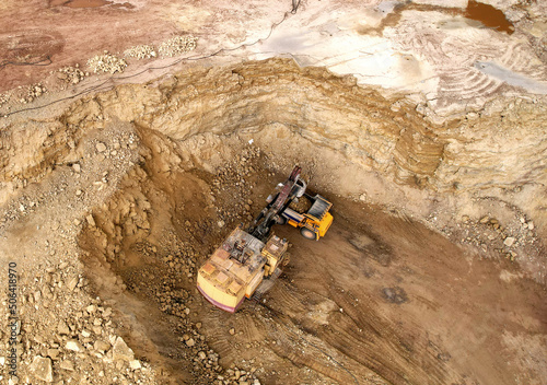 Excavator in open pit on dolomite development. Mining clay in quarry. Opencast for the extraction limestone. Brick and Tile Industry. Heavy machinery in quarry. Excavator load ore in mining truck.