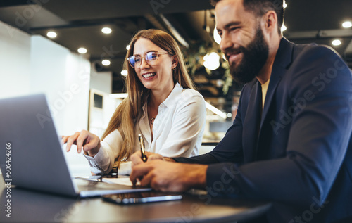 Cheerful businesspeople using a laptop in an office