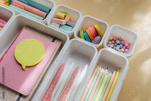 Stylish colored stationery in pastel colors is arranged in white organizers. Creative Drawer Organizing. Storage office supplies. Concept back to school.