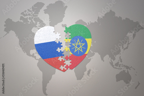 puzzle heart with the national flag of russia and ethiopia on a world map background. Concept.