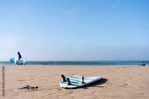 Serf board on the beach. View of nice Atlantic ocean beach with sand ,blue sea and blue sky. Holiday and vacation concept.