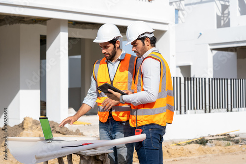 Team engineer and architects are meeting to plan for new project measuring layout of building blueprints in construction site,Construction residential new house in progress at building site.