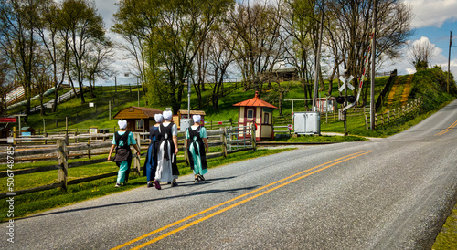 Teenage Amish Boys and Girls Walking Along a Rural Road in the Countryside on a Spring Day