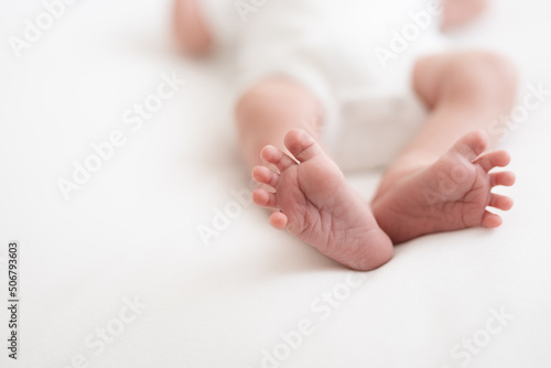 one week old cute newborn infant baby boy expressions tiny feet details 