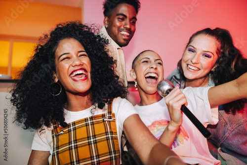 Young friends enjoying karaoke night together