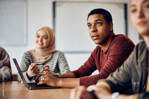 Black male student paying attention during class at university.