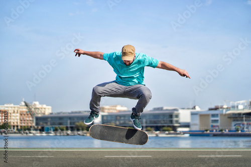 a man doing an ollie flip with his skateboard down a road