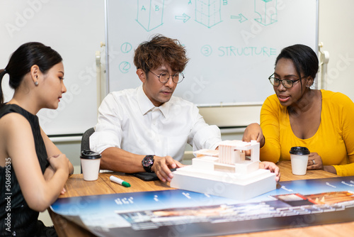 Group of diversity architect designer discuss and critic architecture design project in the office. man presenting and explaining house model to client. team brainstorming for work process