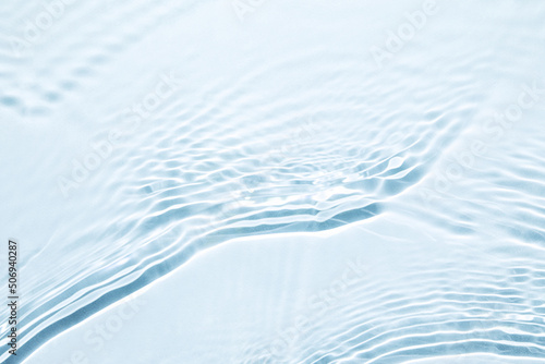 The texture of water on a blue background in bright sunlight.