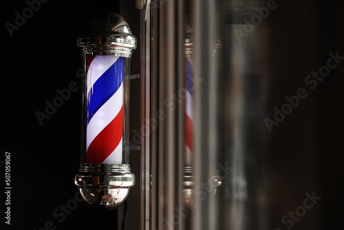 Barber shop vintage pole. copyspace Barbershop. Barber shop pole in red white and blue with lightbulb on top.