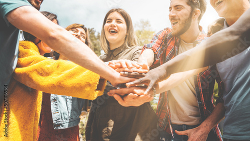 Happy friends joining hands together - union, collaboration and international friendship teamwork concept