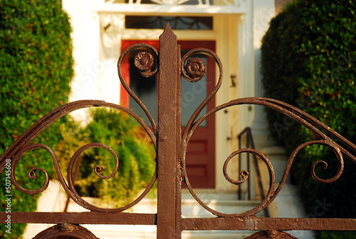 Details of a decorative wrought iron gate on a surrounding fence of an Antebellum manor in Charleston, South Carolina