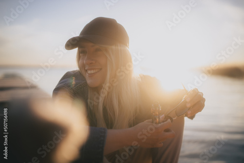 Uśmiechnięta dziewczyna na tle zachodzącego słońca nad jeziorem