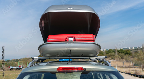 Maleta roja en interior de cofre portaequipajes de coche.