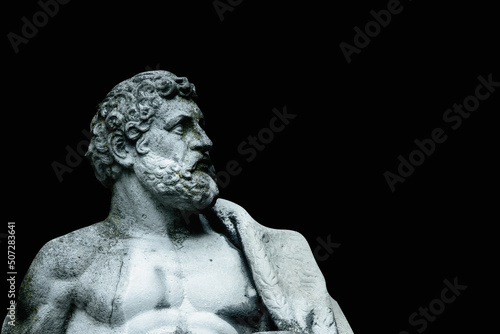 Close up an ancient stone statue of Hercules isolated on black background.