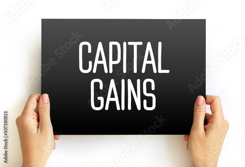 Capital gains - increase in a capital asset's value and is realized when the asset is sold, text concept on card