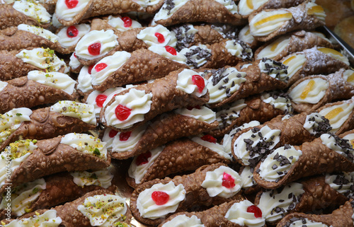 pastries with red cherry called SICILIAN CANNOLI which are the typical dessert of the island of SICILY in the Mediterranean Sea in Italy in Europe