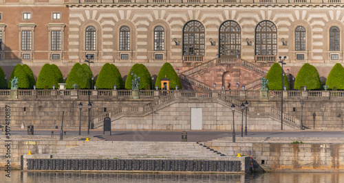 The parterre Logården and the royal castle with stairs and guard and the pier Skeppsbron a sunny day in Stockholm