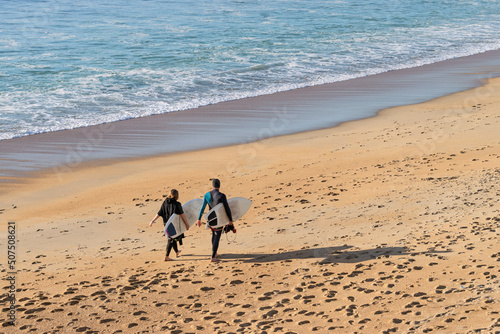 Couple on the beach with surfboards in the afternoon