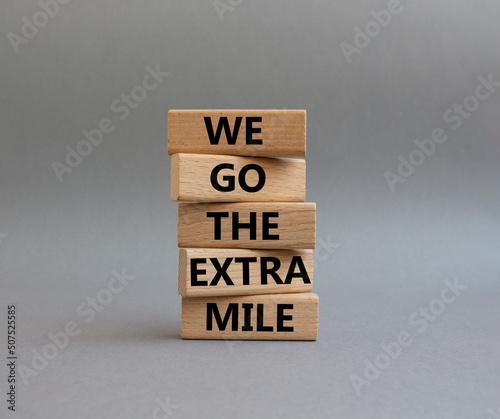 We go the extra mile symbol. Wooden blocks with words 'We go the extra mile'. Beautiful grey background. Business and 'We go the extra mile' concept. Copy space.