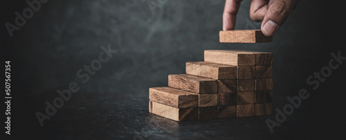 Hand place wooden block stacked concept of prevent collapse or crash of financial business and risk management or strategic planning and insurance.