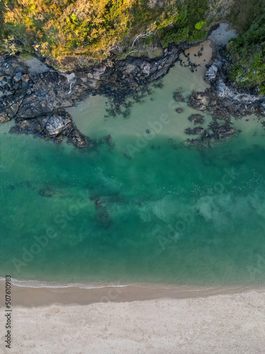 Downward aerial view of beach and crystal clear water