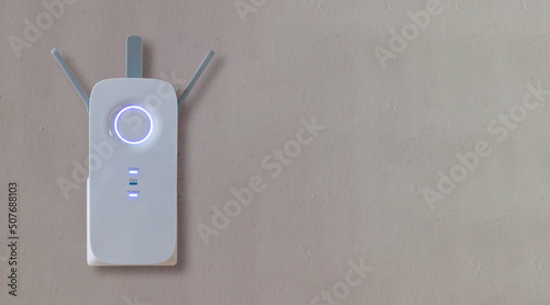 Wireless repeater, Wifi Extender on grey empty wall background. Network booster close up, copy space