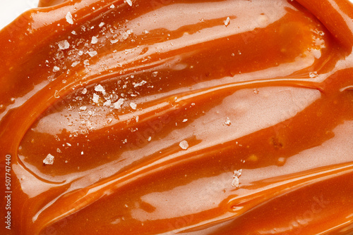 Liquid salted caramel syrup. Background of salted caramel paste. Texture Close up, top view.