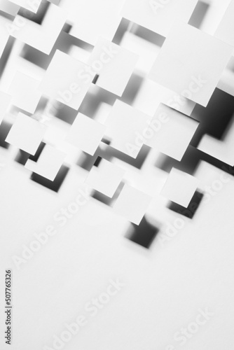 White abstract background - geometric pattern of flying rhombuses in bright light with strict contrast black shadows as border, copy space, top view. Simple minimal backdrop for advertising, design.