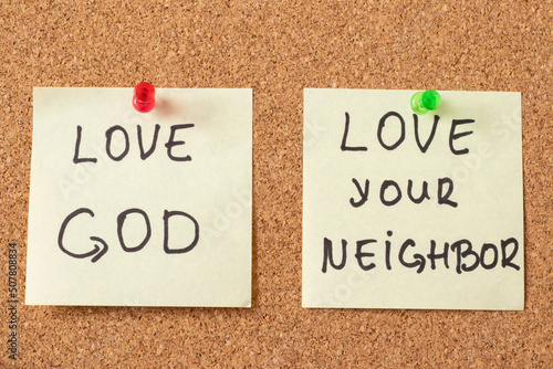 Love God, love your neighbor, handwritten notes on a pinning board. The biblical concept of Christian faith and obedience to Jesus Christ, the greatest commandment from Bible. Top view, a close-up.