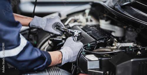 Professional mechanic working on the engine of the car in the garage. Car repair service.