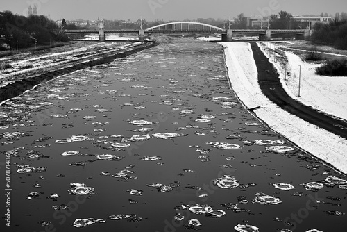 Floe on the Warta River and a road bridge during winter in the city