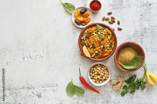 Vegan Moroccan Bulgur with Chick Peas, spinach, dried apricots and date fruit. Traditional African Tajine dish. Flat layot