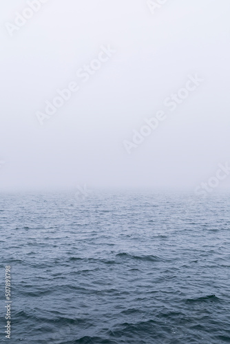 View of waves on the ocean with vanishing horizon on a foggy day. Copy space. Good for natural sea background.
