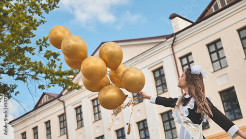 Happy Russian schoolgirl on the last day of school with balloons.