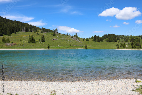 Beautiful lake with clear clear water and alpine mountains in the background