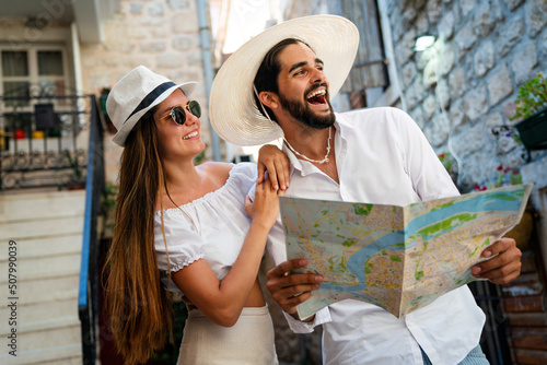Happy tourists couple in love sightseeing city with map during summer vacation