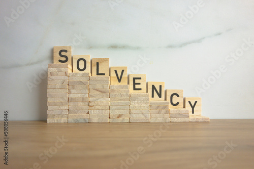 Wooden stairs down with word solvency. Creditworthiness, banking conditions concept