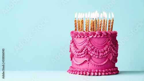 Elaborate birthday cake with vintage style buttercream icing and gold birthday candles