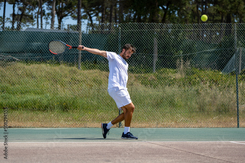 Tennis player hitting backhand at ball