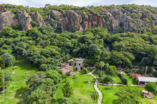 Tobati, Cordillera, Paraguay - May 09, 2022: Aerial view of the Castle of the Knights Templar (Castillo Caballero Templario) in Tobati in Paraguay against the impressive backdrop of a rock face.