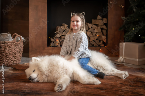 Nicole. Girl and samoyed husky dog. Home