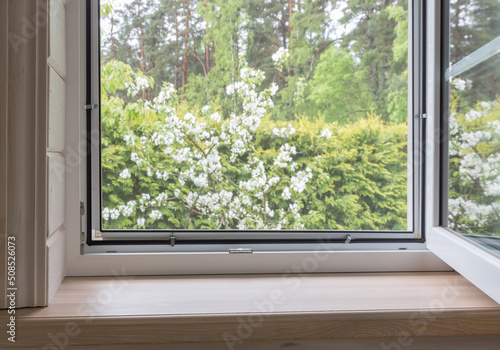 White window with mosuito net in a rustic wooden house