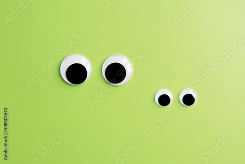 invisible frog googly eyes on green color background