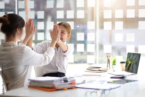 Businesswoman and office colleagues express excitement and happiness as the job is accomplished and the bonus is awarded.