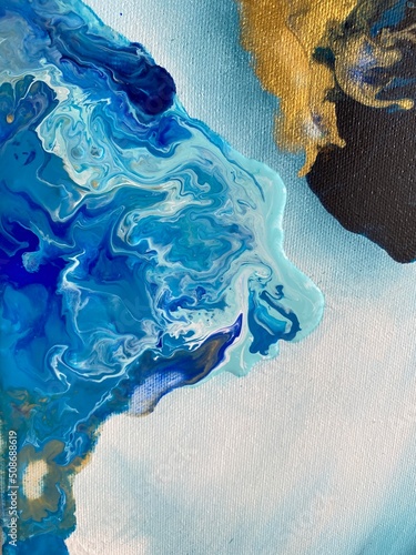 Mélange de peinture bleue, turquoise, noire et or sur une toile. Passe-temps artistique et créatif. Abstraction en peinture acrylique et à l'huile. Peinture fluide sur un canevas.